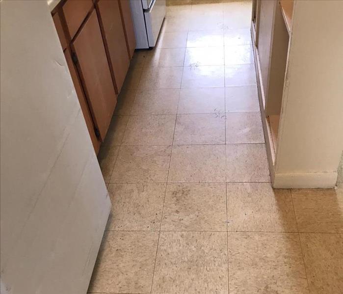 A tiled floor is dirty.