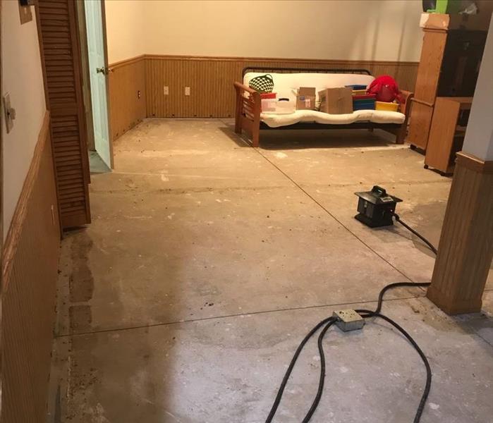 The carpet in a basement living room has been removed.