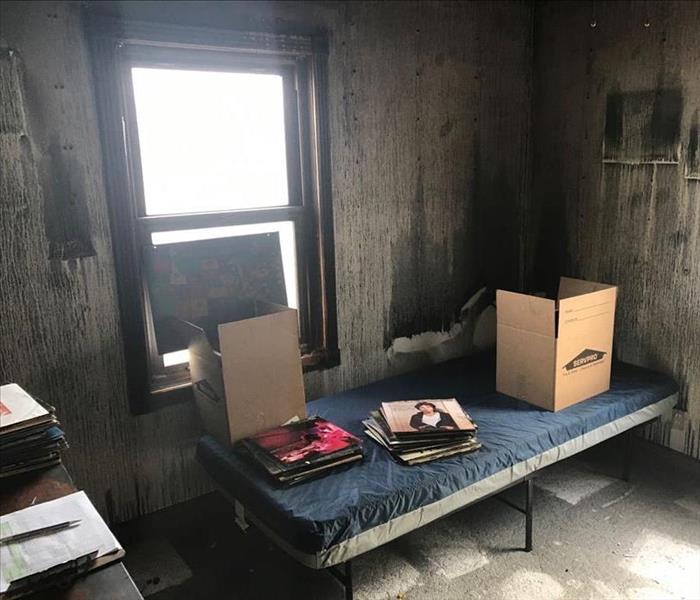 A bedroom and its walls has been damaged by fire.
