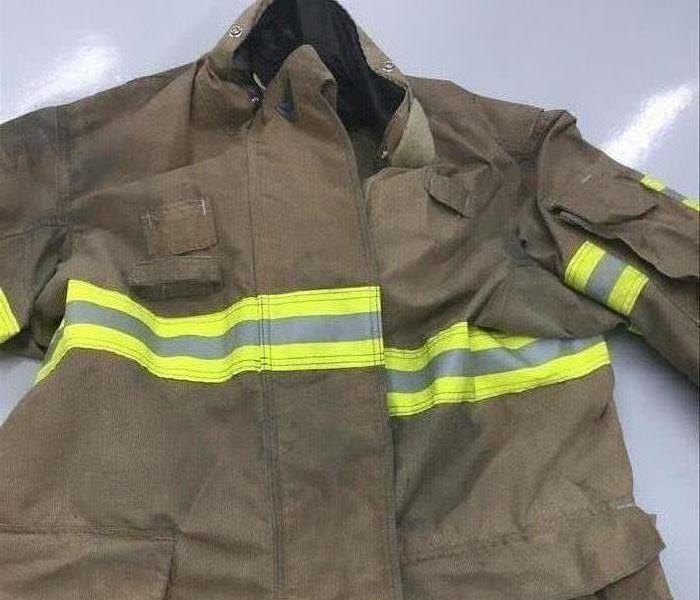image of a local firemen's jacket looking dark and visibly showing dirt