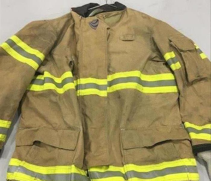 image of same firemen's jacket after it has been cleaned and restored, looking lighter