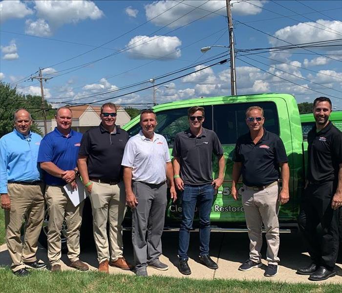 image of servpro owners and employees smiling in front of a servpo truck