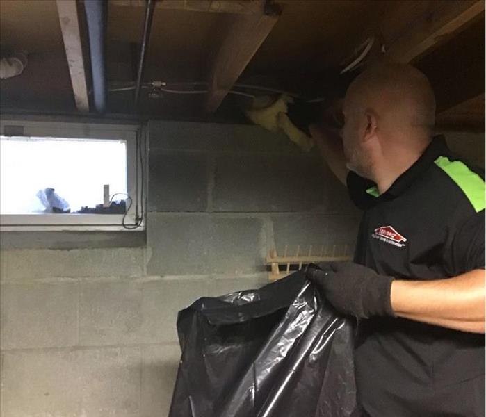 SERVPRO team member is bagging insulation in a basement.