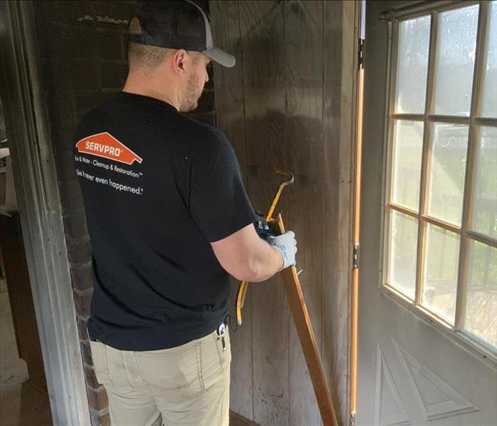 SERVPRO team member works to restore a wall damaged from fire.