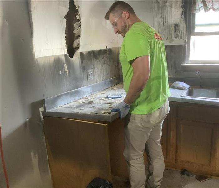 SERVPRO team member is removing a countertop from a fire damaged kitchen.