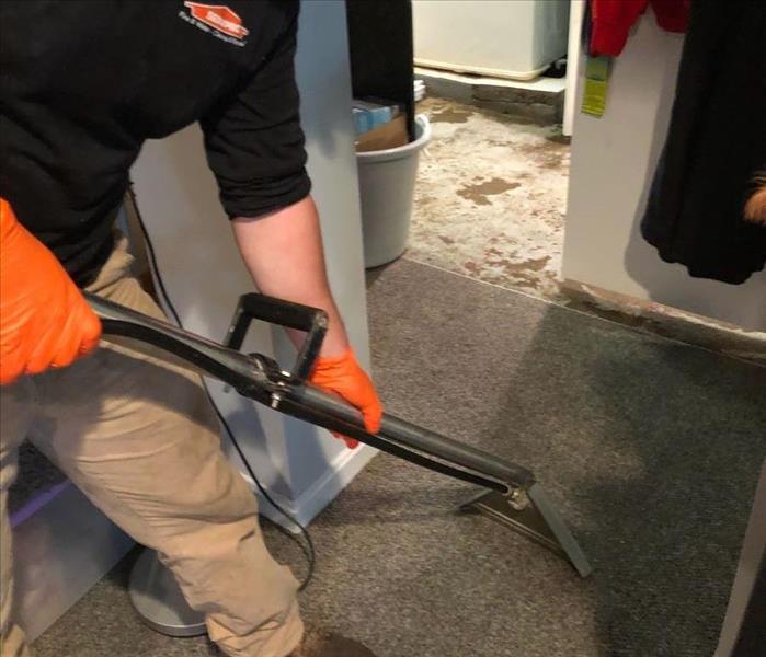 image of SERVPRO worker using a hot water extractor when cleaning water damage