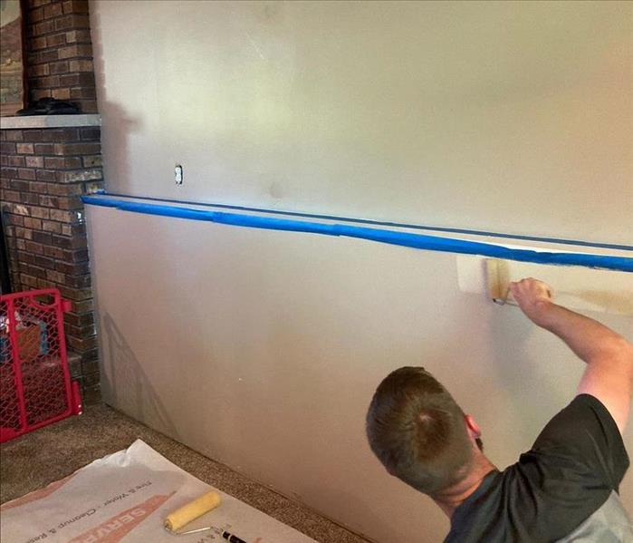 SERVPRO team member is painting a wall.